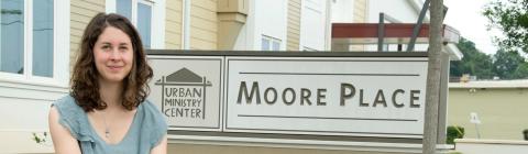 Elizabeth Welliver '16 sits on pavement next to the Moore Place  organization sign