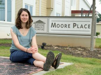 Elizabeth Welliver '16 sits on pavement next to the Moore Place  organization sign