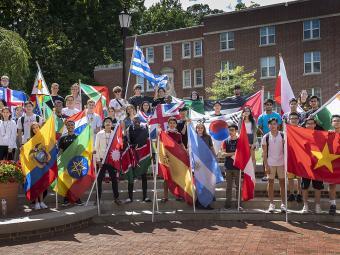  international students group holds country flags outside college union amphitheatre