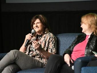 Amy Ray seated next to Emily Saliers on stage at  College following screening of documentary